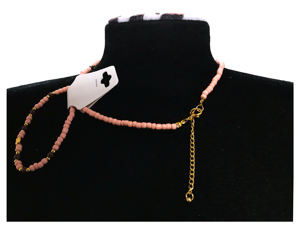 Necklace with pink beads and gold chain on a black mannequin bust.