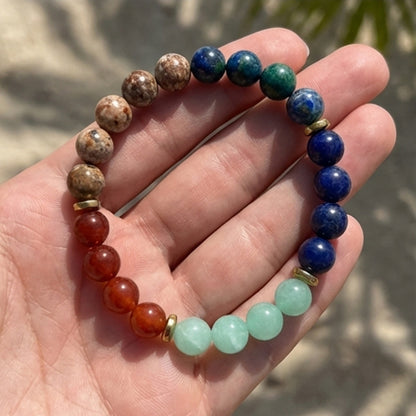 Beaded bracelet with multicolored beads held in a hand against a blurred natural background
