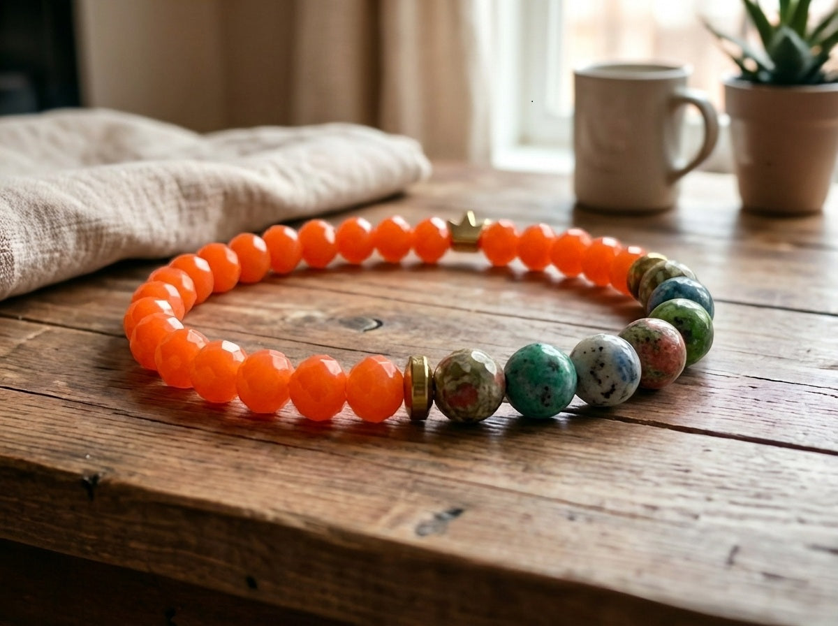 Necklace with orange beads and multicolored stones on a wooden surface