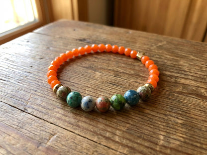Handmade Orange and multicolor bracelet on top of a wooden table