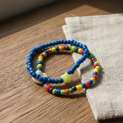 Colorful beaded bracelets on a wooden surface with a fabric background