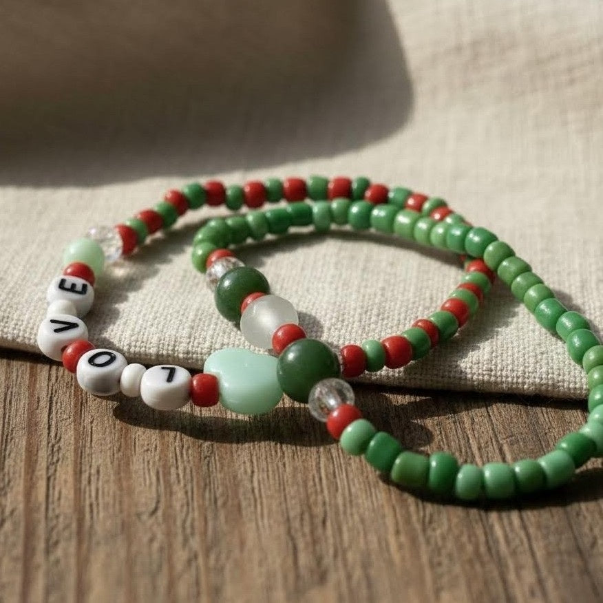 Green, red, and white beaded necklace on a wooden surface