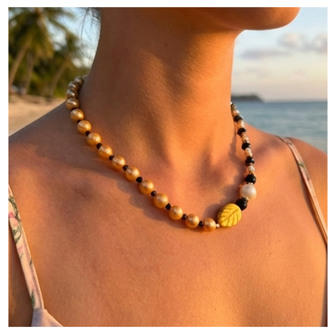 Necklace with leaf-shaped beads worn by a person with a beach background