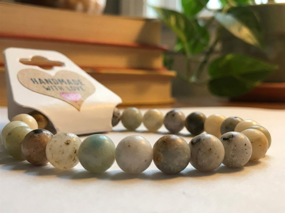 Beaded bracelet on a surface with a 'Handmade with Love' card in the background.