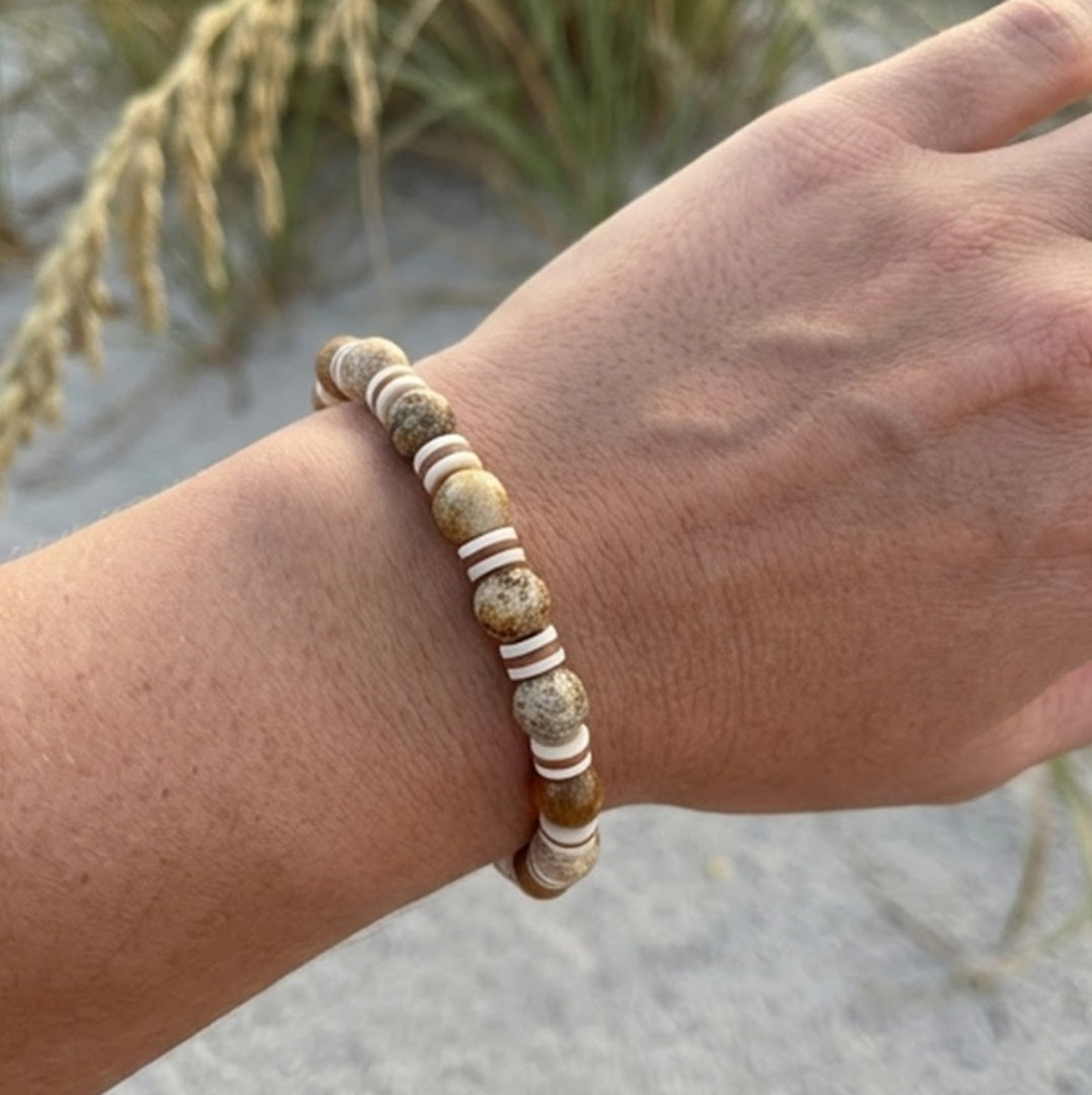 Earthy tones beaded bracelet on a wrist with a natural background