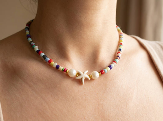 Colorful beaded necklace with a starfish charm worn by a woman