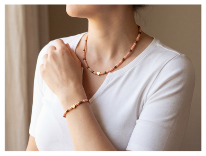 Person wearing a beaded necklace and bracelet against a neutral background