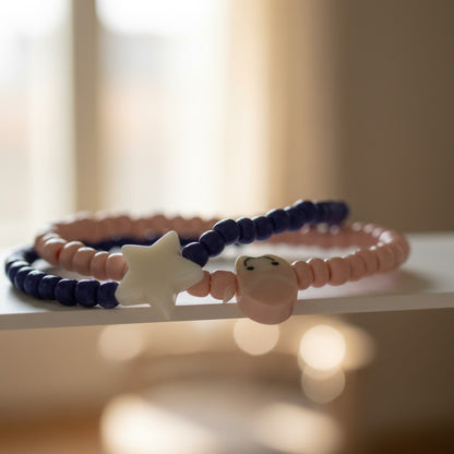 Three beaded bracelets with star and cat-shaped beads on a white surface.