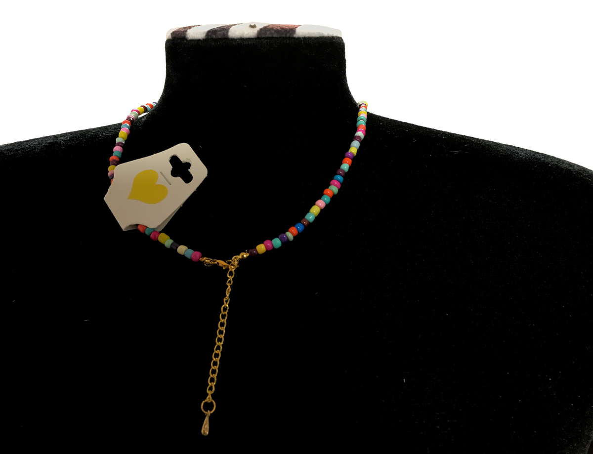 Necklace with colorful beads and gold chain on a black mannequin bust.