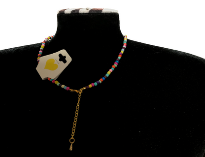 Necklace with colorful beads and gold chain on a black mannequin bust.