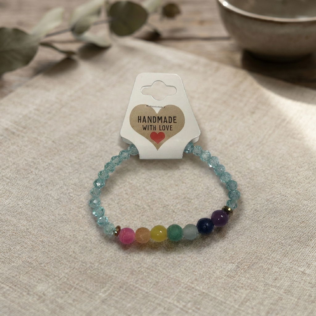 Multicolored beaded bracelet on a beige surface with a 'Handmade with Love' card.