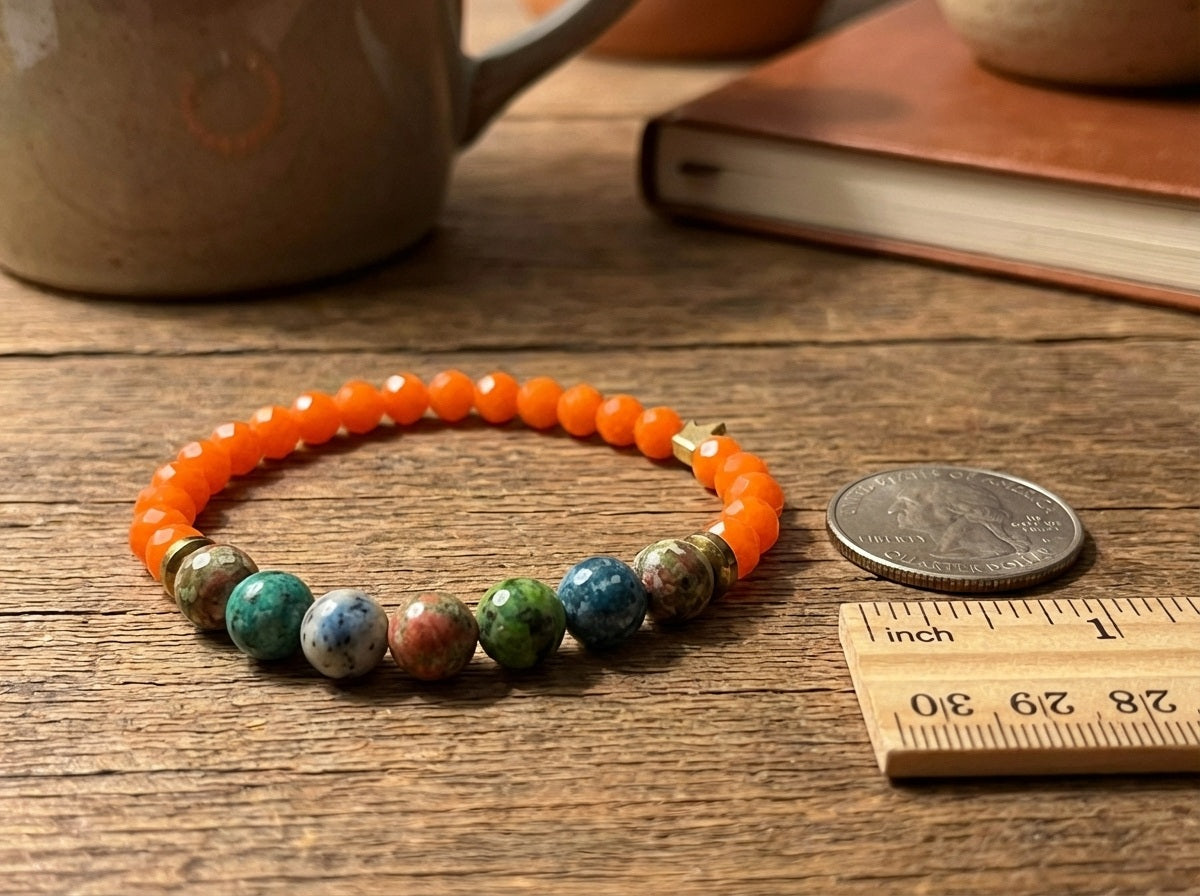 Multicolored beaded bracelet on a wooden surface with a coin and ruler for scale.