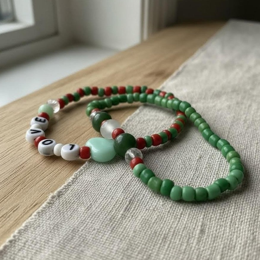 Green beaded necklace with letter beads on a textured surface