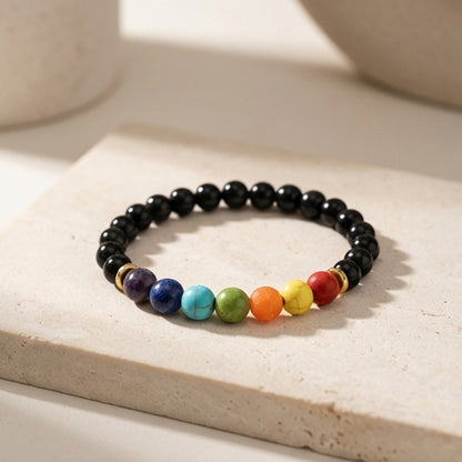 Black beaded bracelet with colorful beads on a light surface