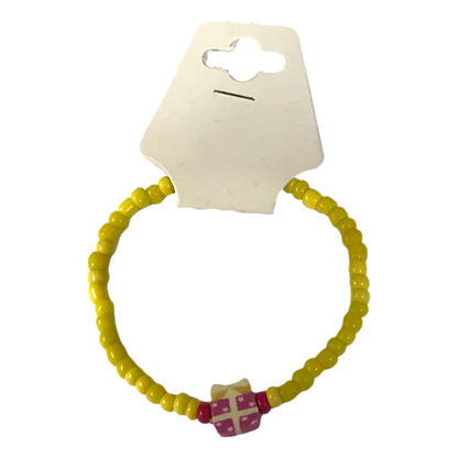 Yellow beaded bracelet with a pink and white heart charm on a white background