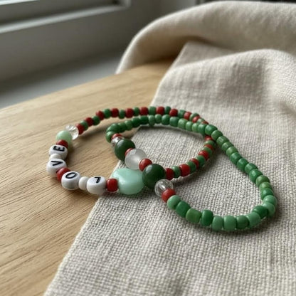 Green beaded bracelet with letter beads on a textured surface