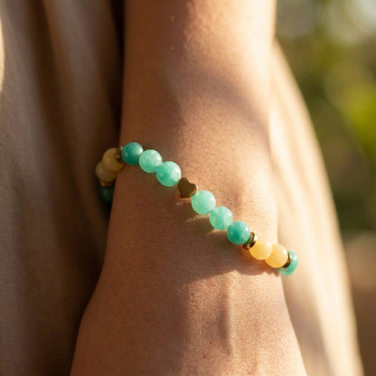 Close-up of a wrist wearing a bracelet with green and yellow beads.