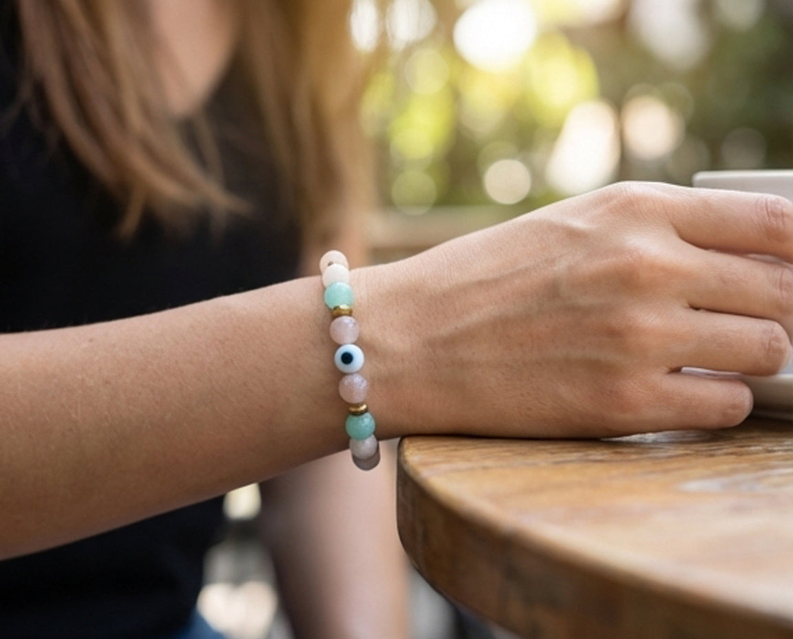 Person wearing a colorful beaded bracelet on a blurred outdoor background