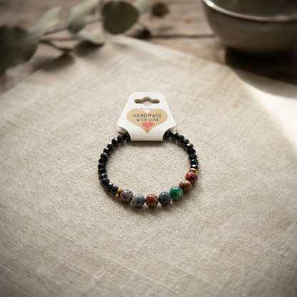 Beaded bracelet on a beige surface with a 'Handmade with Love' card.