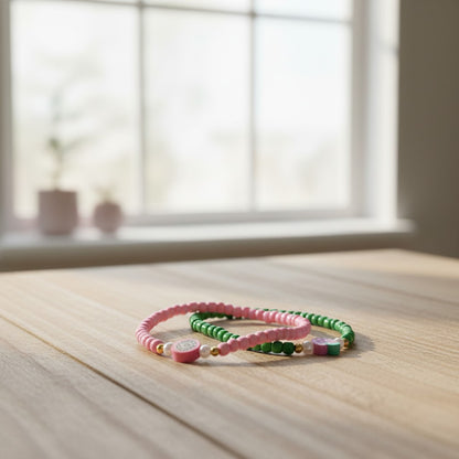 Two colorful beaded bracelets on a wooden surface with a blurred window background