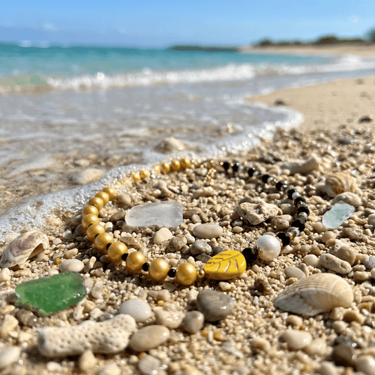 Beaded bracelet on a beach with ocean waves in the background