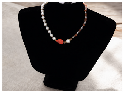 Necklace with a red leaf-shaped pendant on a black mannequin bust.