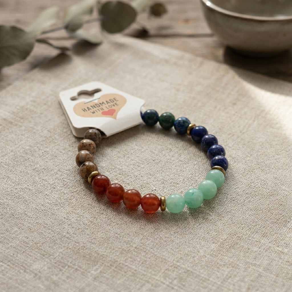 Multicolored beaded bracelet on a beige surface with a 'Handmade with Love' tag.