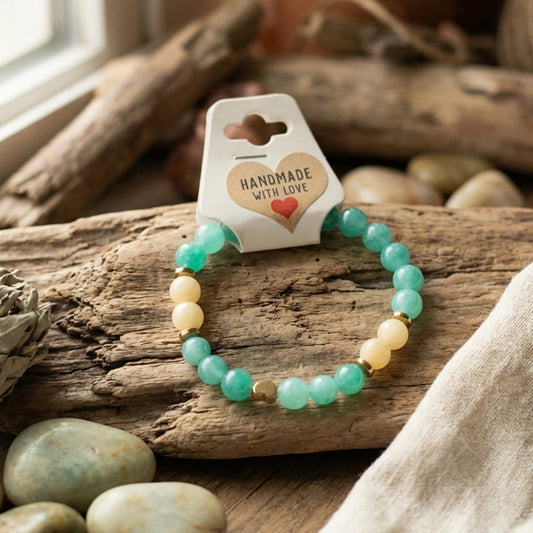 Beaded bracelet on a wooden log with 'Handmade with Love' packaging