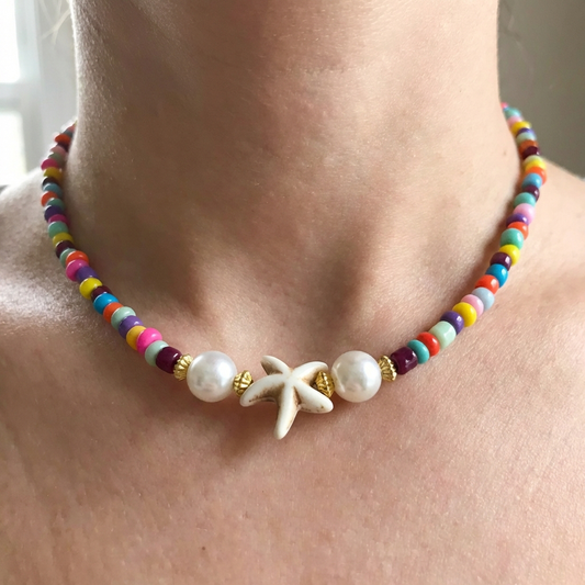 Colorful beaded necklace with a starfish charm worn by a person