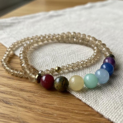 Set of beaded bracelets on a wooden surface with a white fabric background