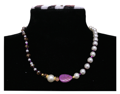 Necklace with pearls and purple shell beads on a black mannequin.