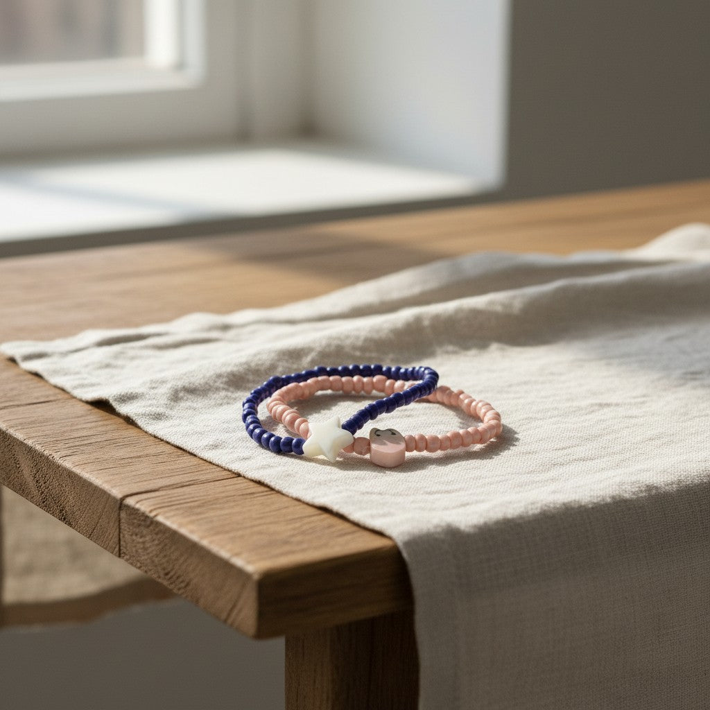 Two beaded bracelets on a wooden surface with a soft light background