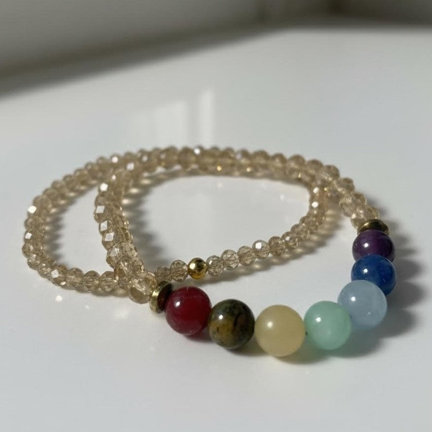 Beaded bracelets with clear, colored, and gold beads on a white surface