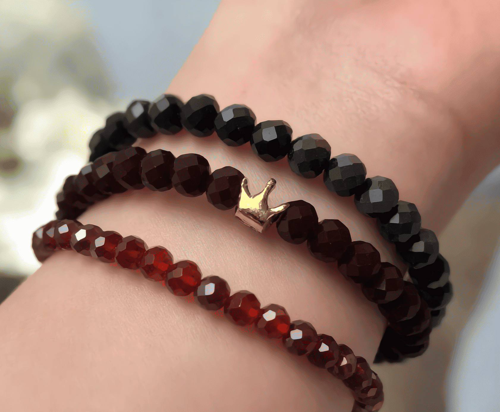 Three beaded bracelets on a wrist with a blurred background