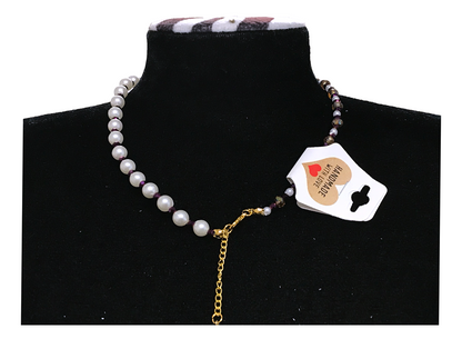 Necklace with a heart-shaped tag on a black stand
