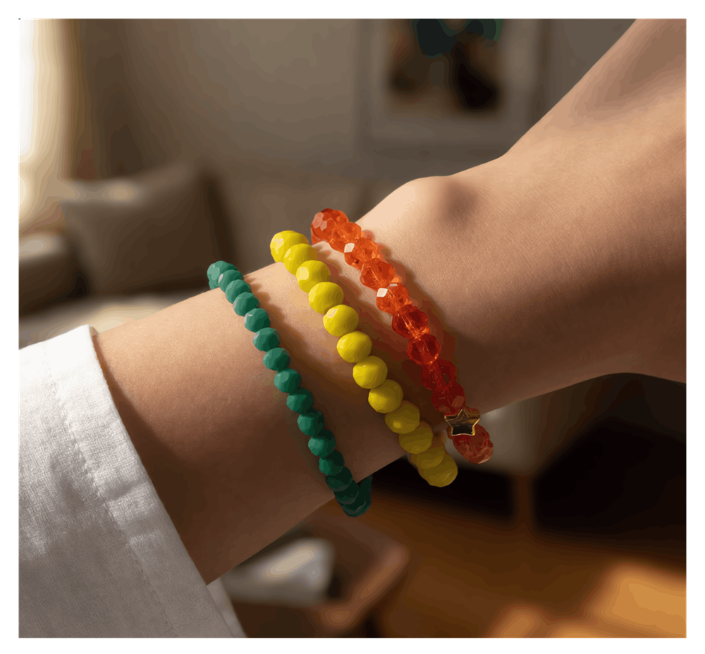 Three colorful beaded bracelets on a wrist with a blurred indoor background