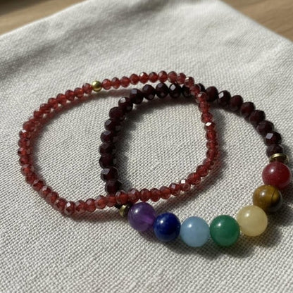 Two beaded bracelets on a light fabric background