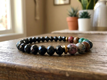 Multicolored beaded bracelet on a wooden surface with plants in the background